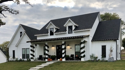 Roofline holiday lights and porch garland on a west Fort Worth home