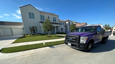 Denmark Lawn truck on a west Fort Worth street in front of a treated lawn